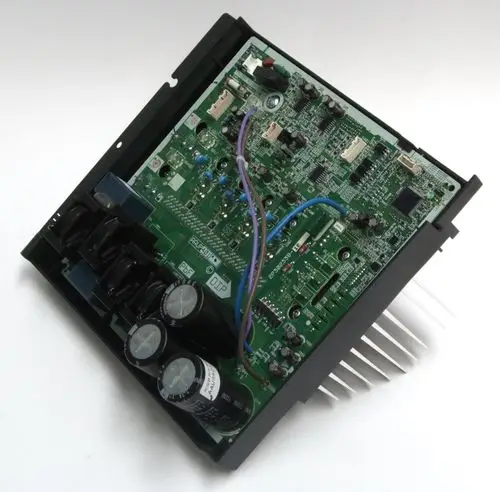 Grüne elektronische Platine mit mehreren Bauteilen, darunter Kondensatoren und Kühlkörper, als Bestandteil von Daikin Klimaanlagen.